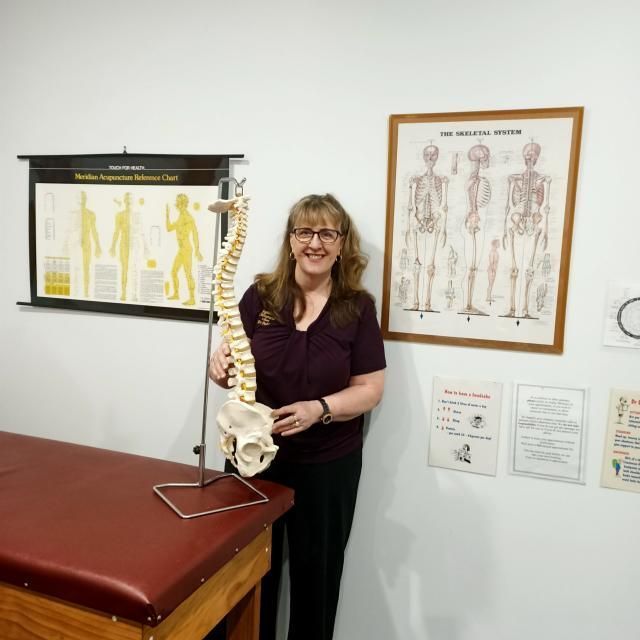 A Man is Giving a Woman a Massage on a Bed — Sugarland Chiropractic Centre in Avoca, QLD