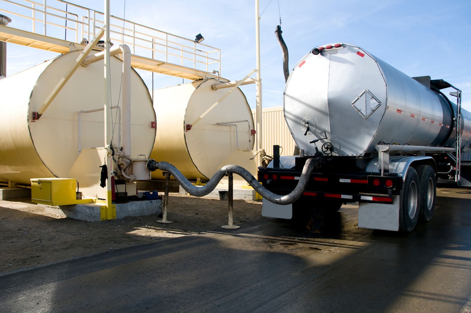 Two tanker trucks are parked next to each other in a parking lot