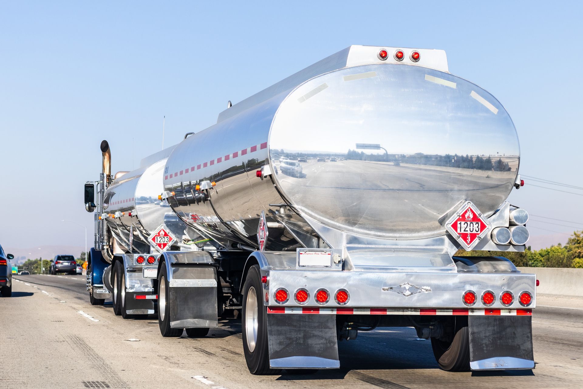 A tanker truck is parked on the side of a highway.