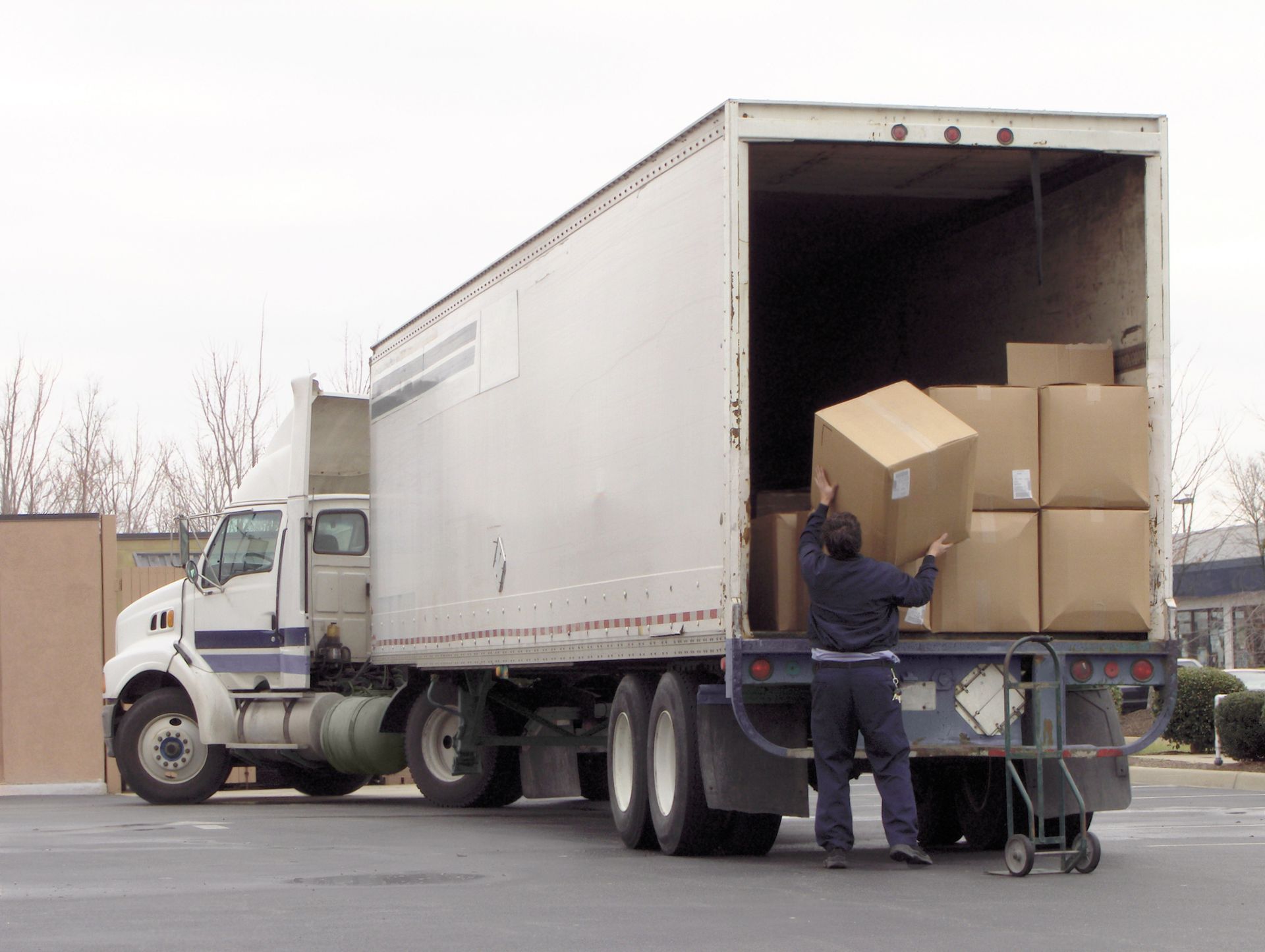 A man is loading boxes into a semi truck
