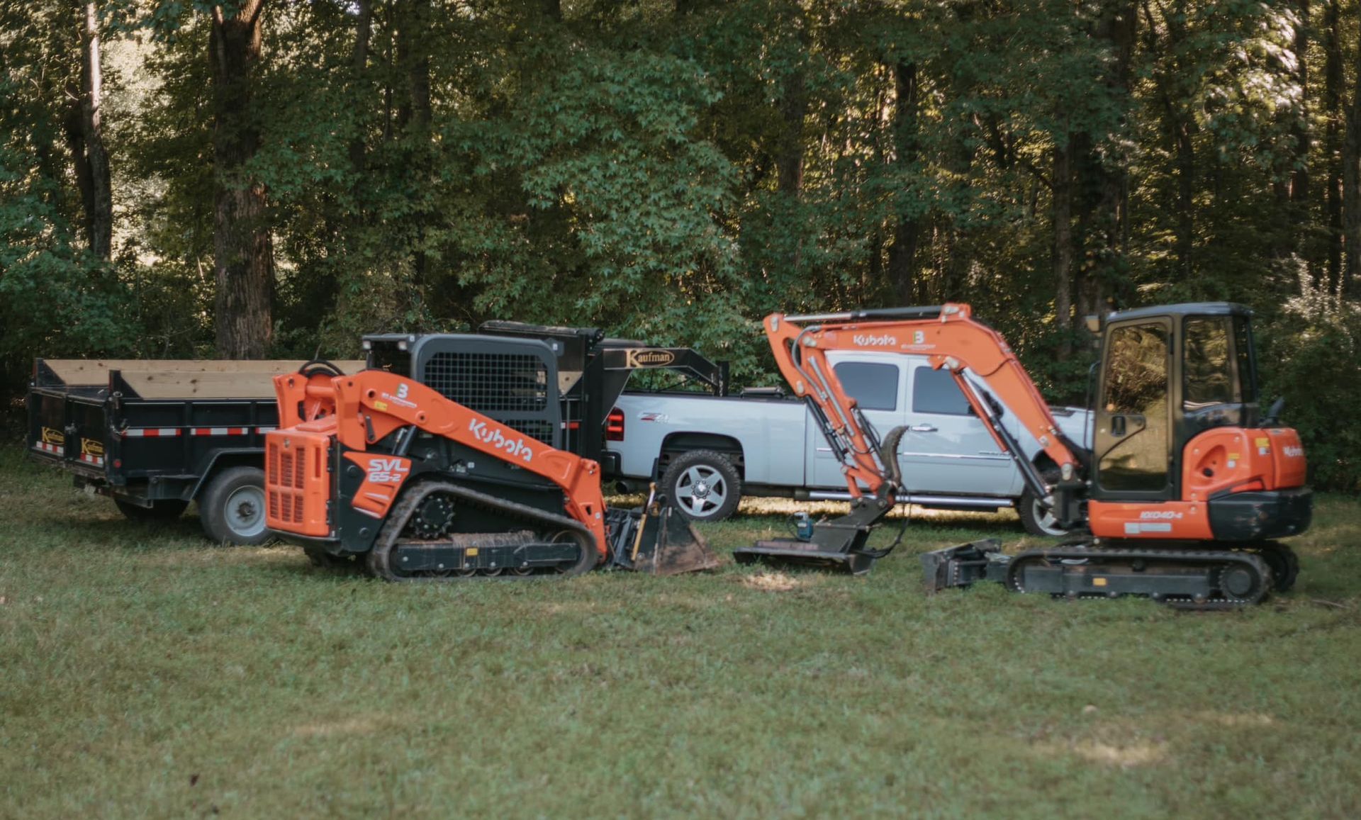 A couple of tractors are parked next to each other in a field.