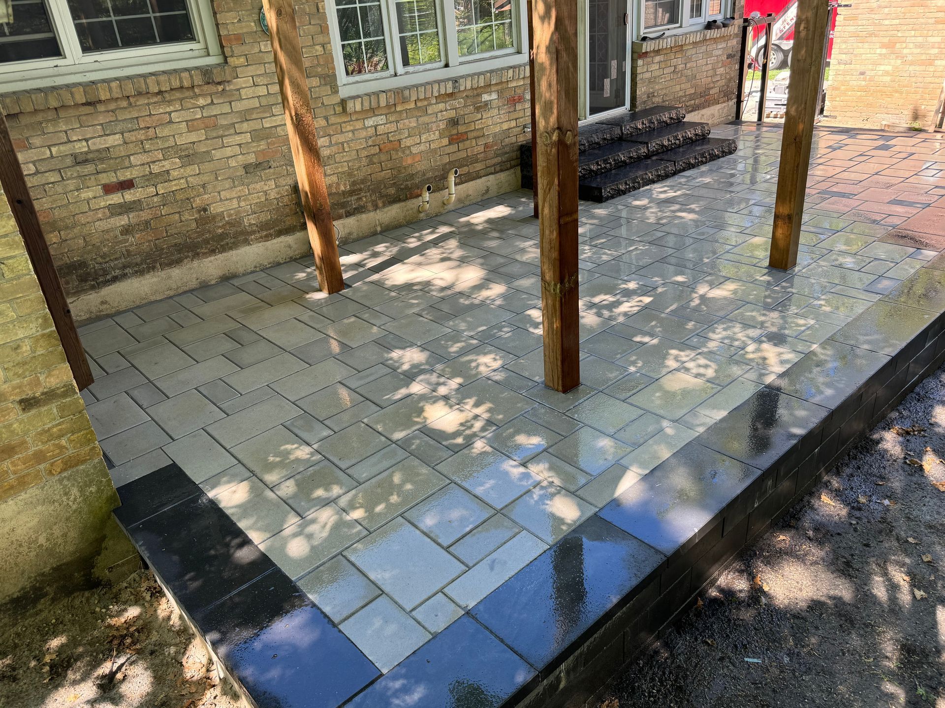 A patio is being built in front of a brick house.