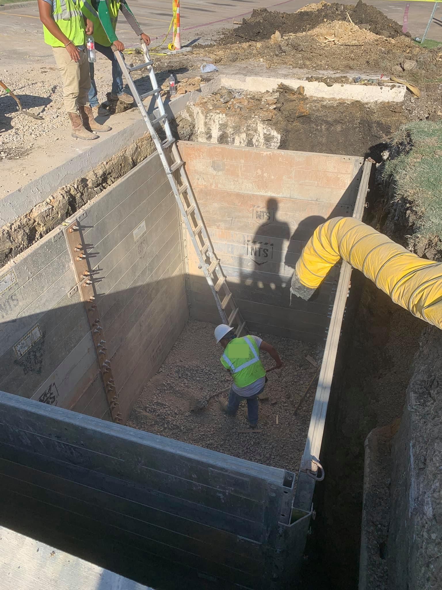 Calhoun Plumbing Services LLC | A group of construction workers are working in a large hole.