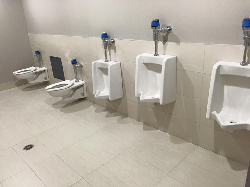 A row of urinals and toilets in a public restroom.