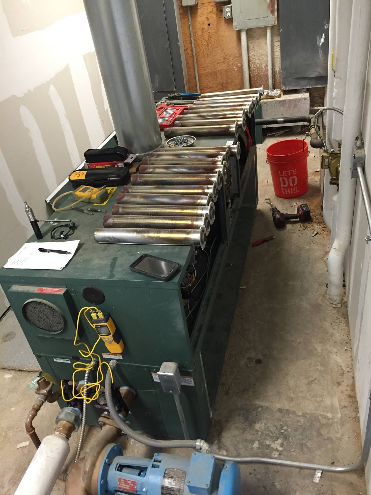 Calhoun Plumbing Services LLC | A green machine is sitting in a room next to a red bucket.