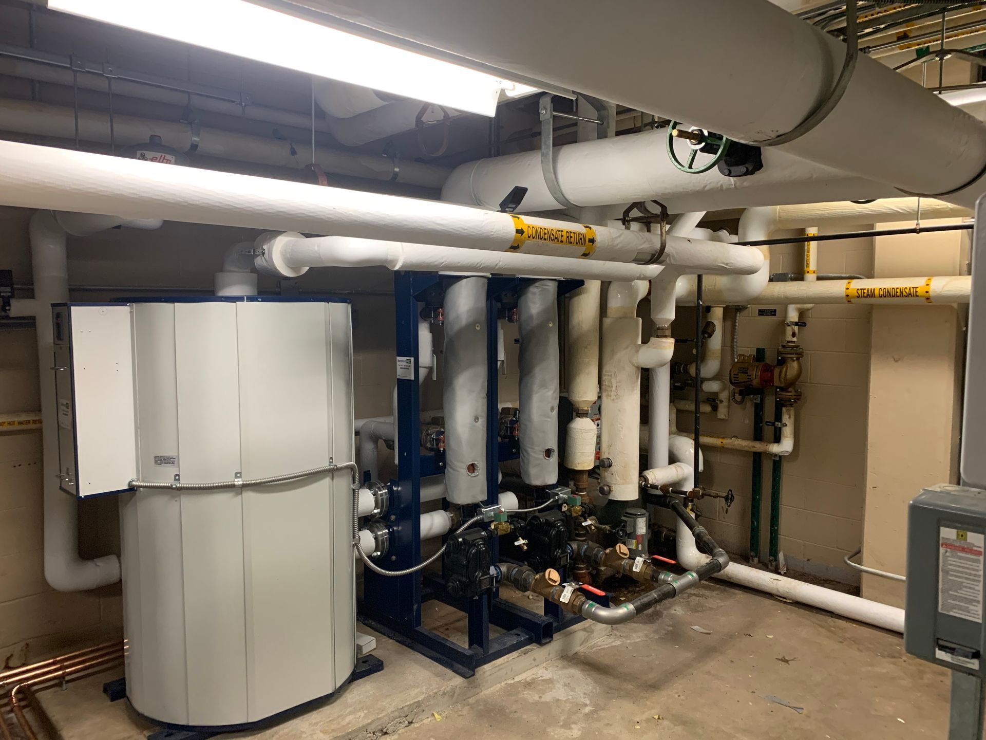 Calhoun Plumbing Services LLC | A room with a lot of pipes and a boiler in it.