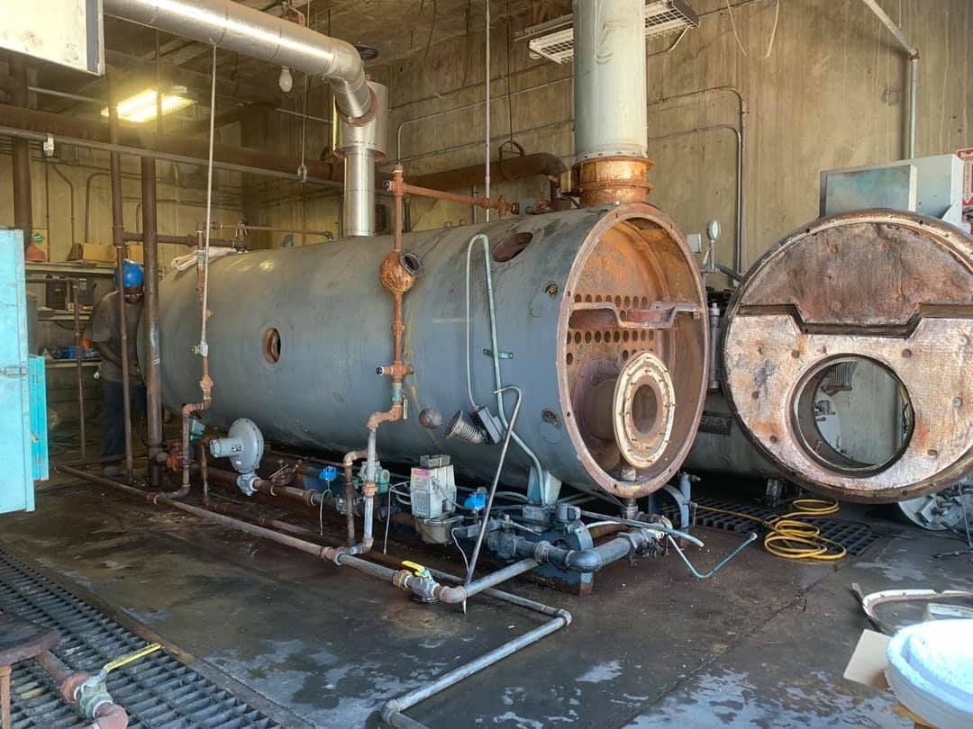 Calhoun Plumbing Services LLC | A large boiler is sitting inside of a building.