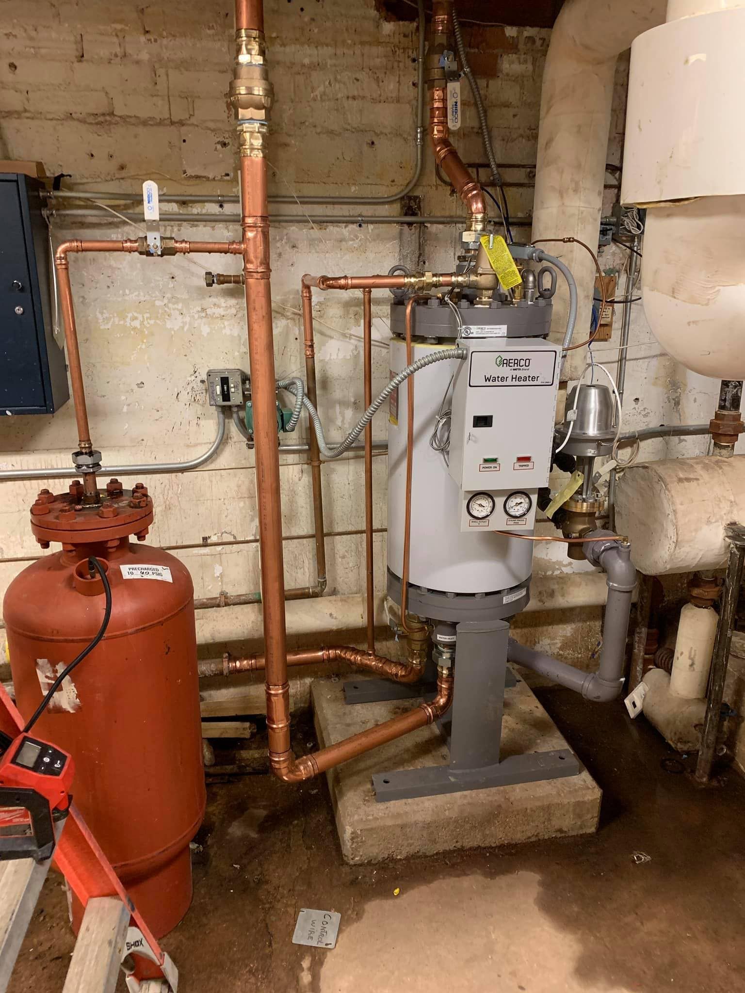 Calhoun Plumbing Services LLC | A room with a lot of pipes and a ladder.