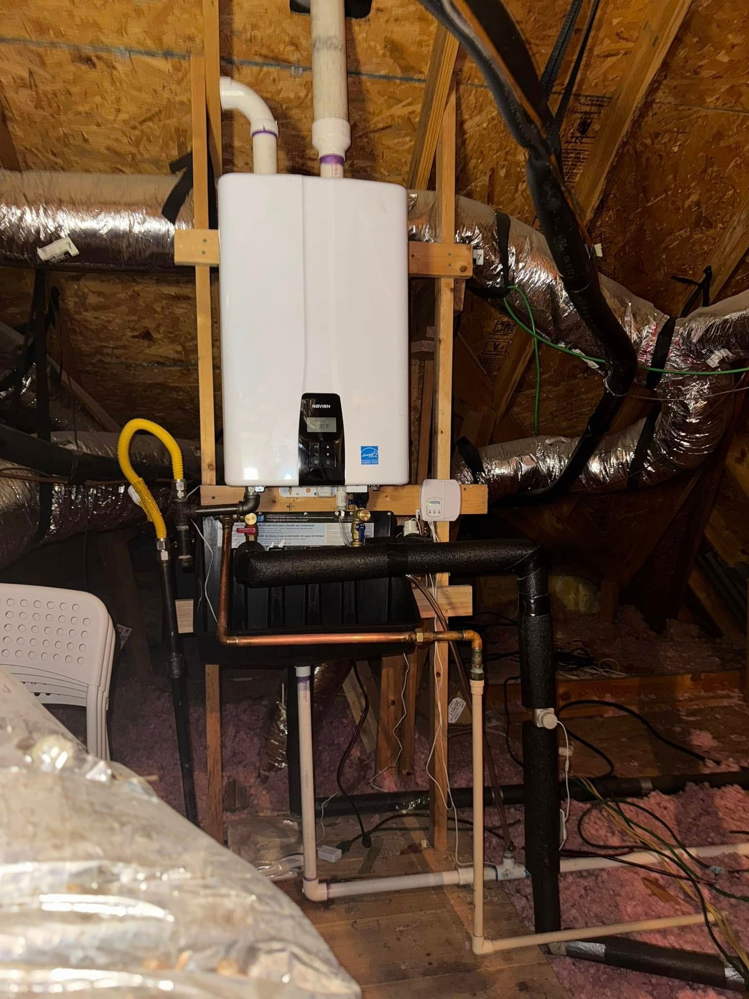 Calhoun Plumbing Services LLC | A white water heater is mounted to the ceiling in an attic