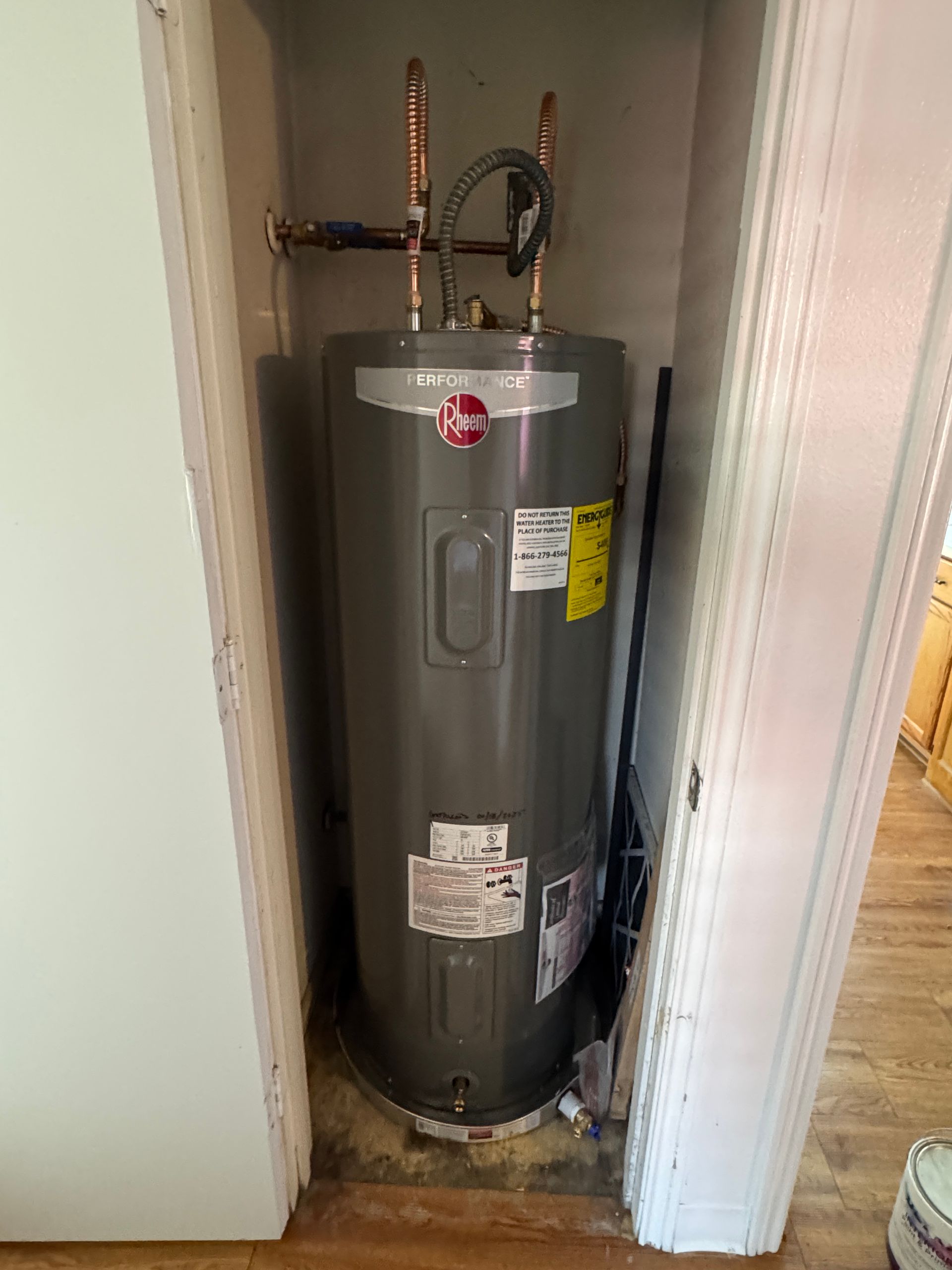 Calhoun Plumbing Services LLC | A water heater is sitting in a closet next to a door.