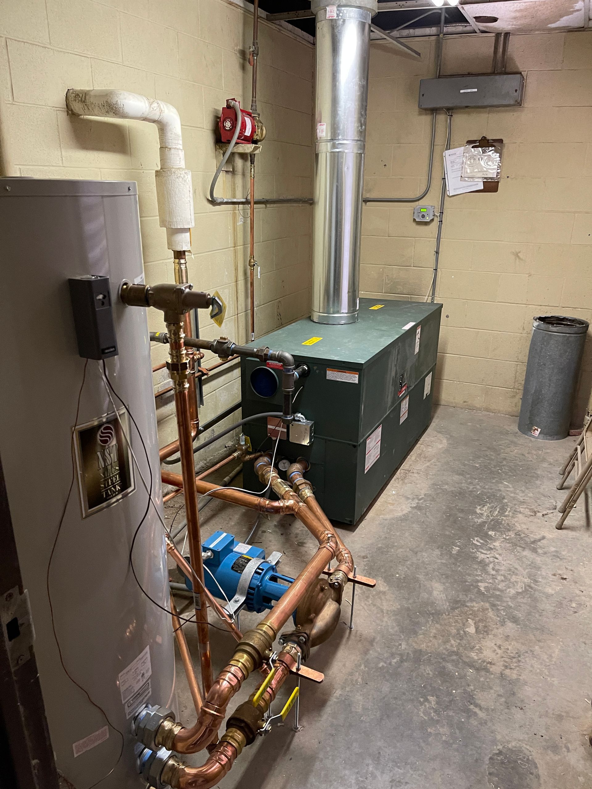 Calhoun Plumbing Services LLC | A room with a water heater and a boiler in it.