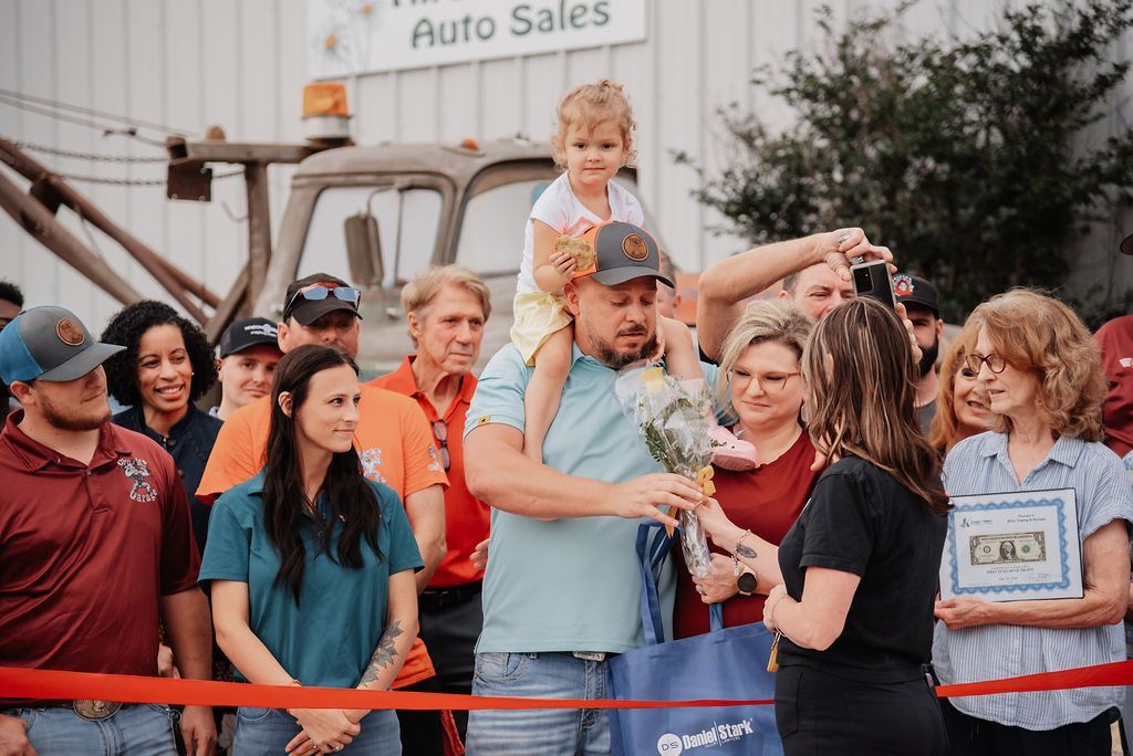 A group of people are standing in front of a tow truck. | Chuck's Garage