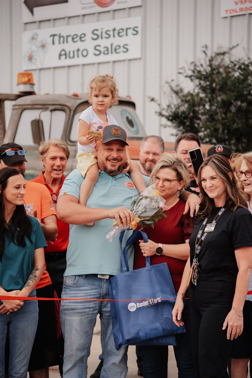 A group of people are standing in front of a building. | Chuck's Garage