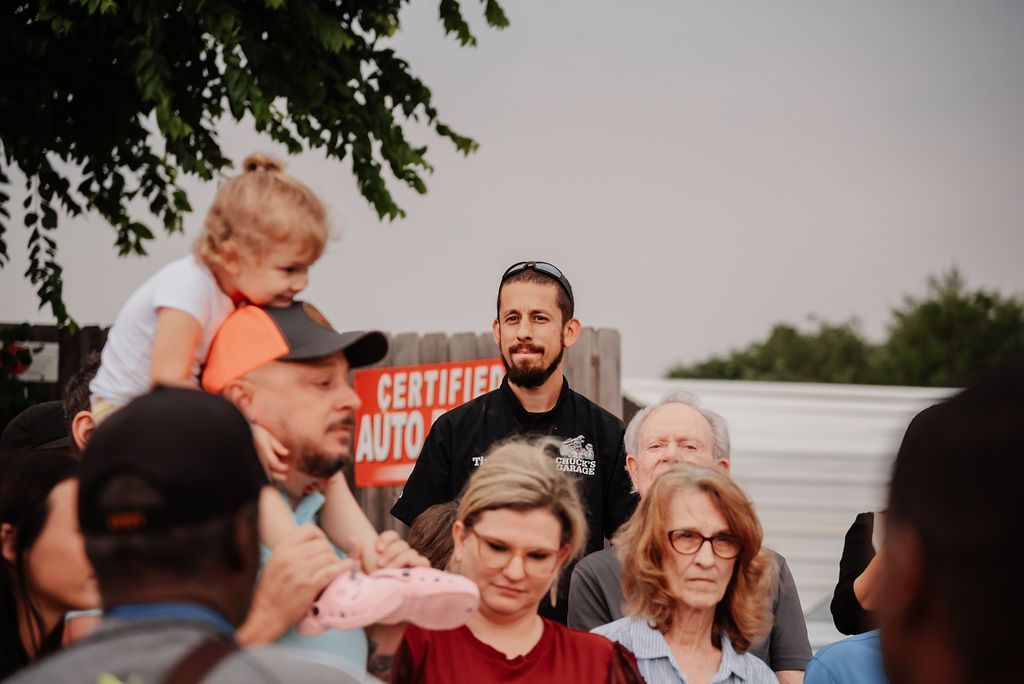 A group of people are standing in front of a certified auto sign. | Chuck's Garage