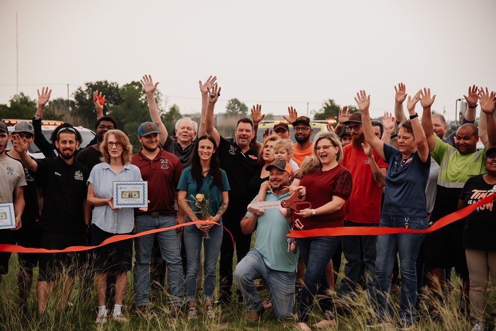 A group of people are standing in a field with their hands in the air. | Chuck's Garage