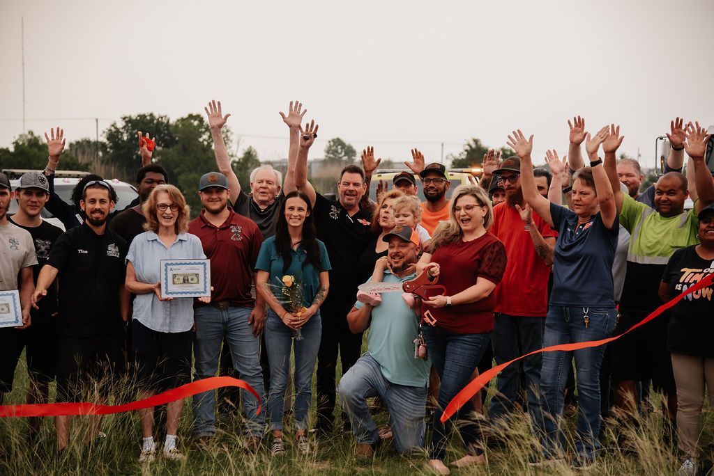 A group of people are standing in a field with their hands in the air. | Chuck's Garage