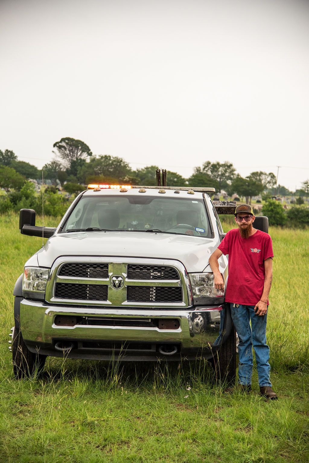 A man is standing in front of a truck in a field. | Chuck's Garage