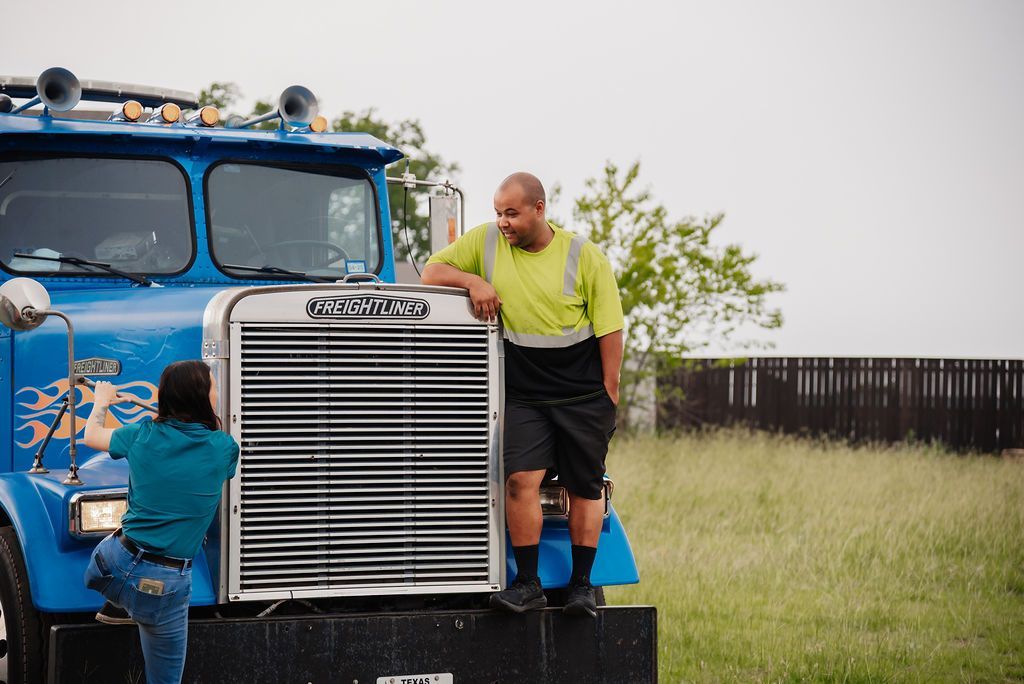 A man and a woman are standing next to a blue truck. | Chuck's Garage