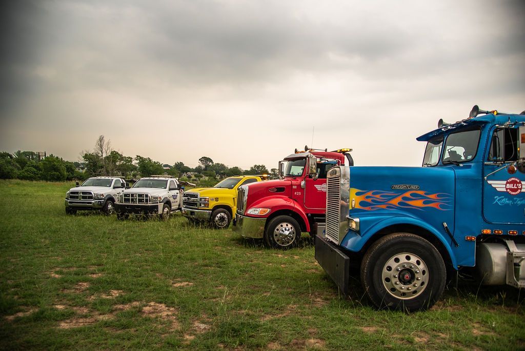 A row of trucks are parked in a grassy field. | Chuck's Garage