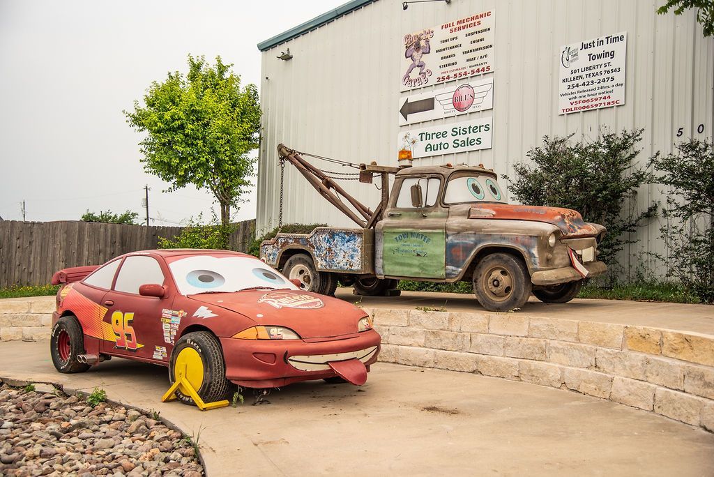 A red car is parked next to a tow truck. | Chuck's Garage