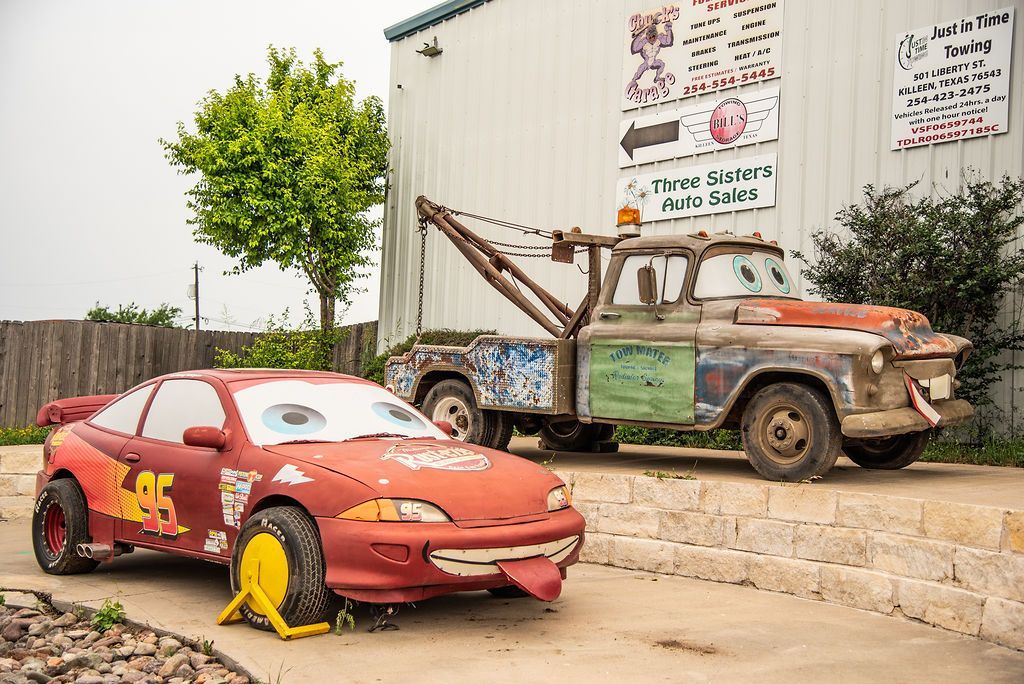 A car and a tow truck are parked in front of a building. | Chuck's Garage