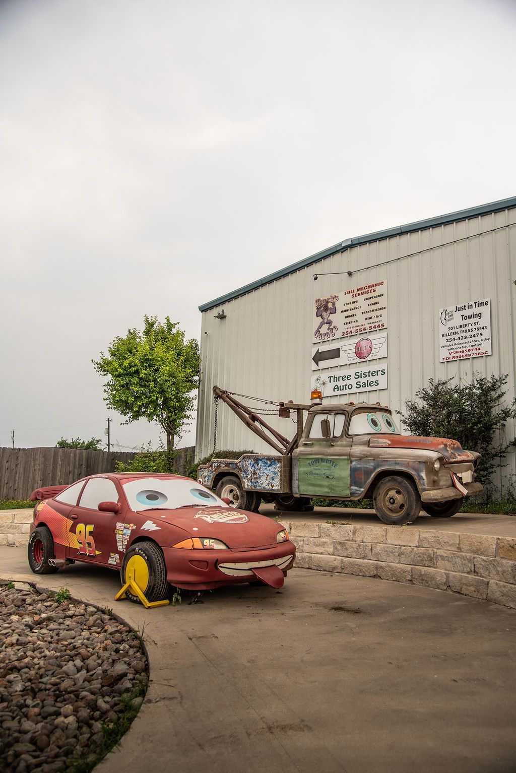 A red car and a tow truck are parked in front of a building. | Chuck's Garage