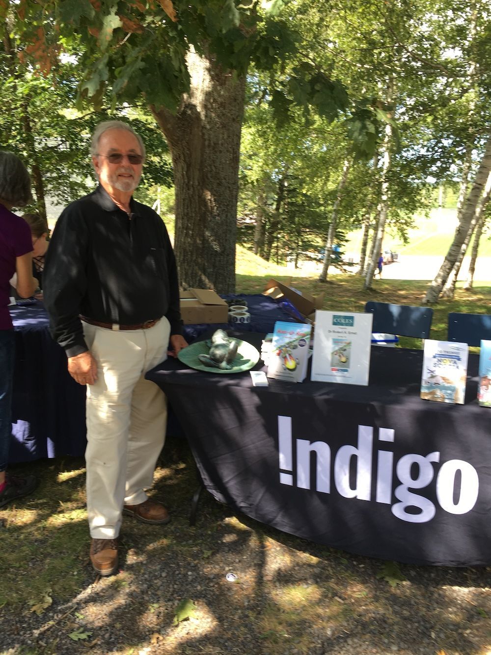 Man stands at a table with the name 