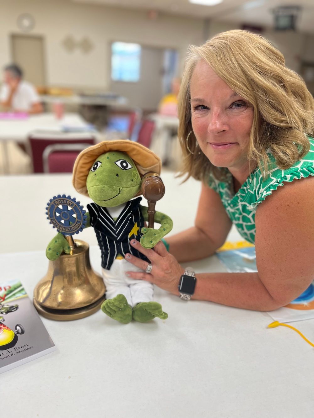 Stuffed frog toy wearing a vest, white pants, and a hat.