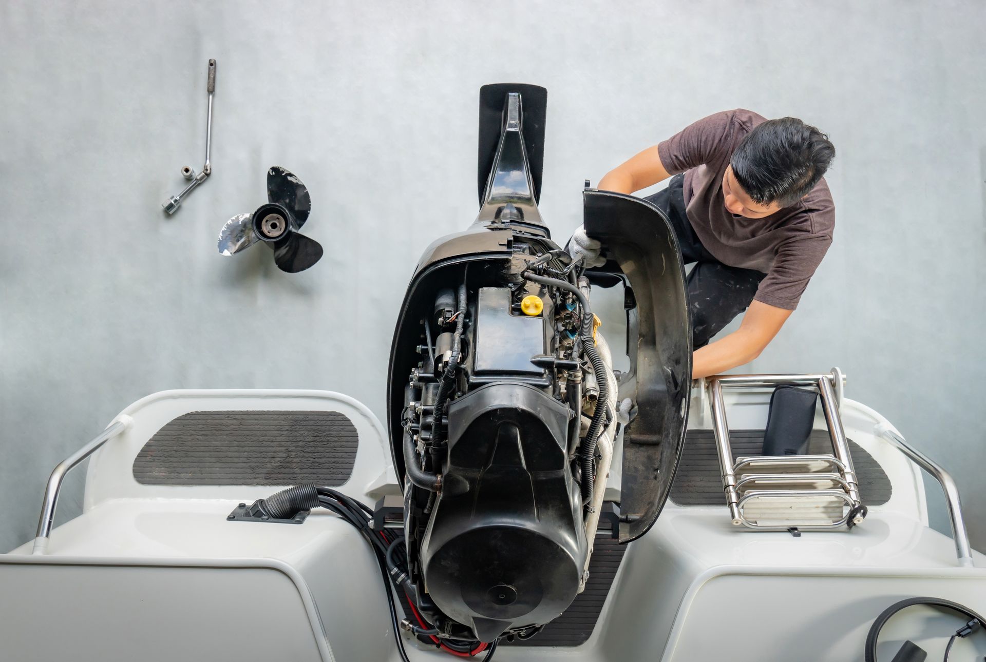 A man is working on the engine of a boat.
