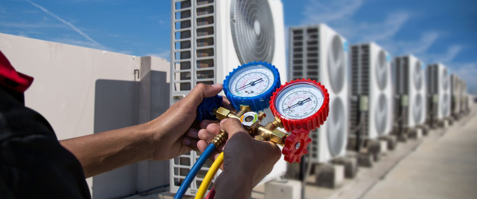 A man is holding a pair of gauges in front of a building.