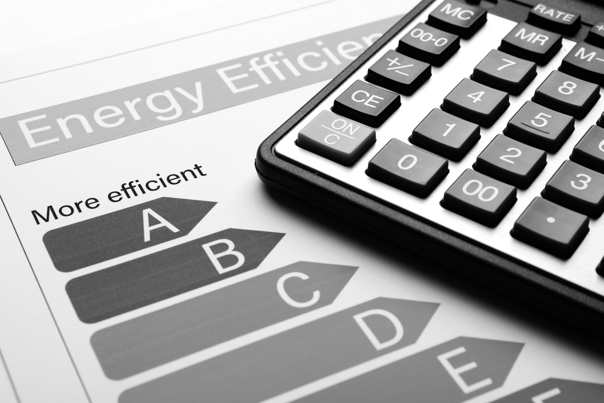 Calculator resting on a paper with energy efficiency rating labels: A to E.