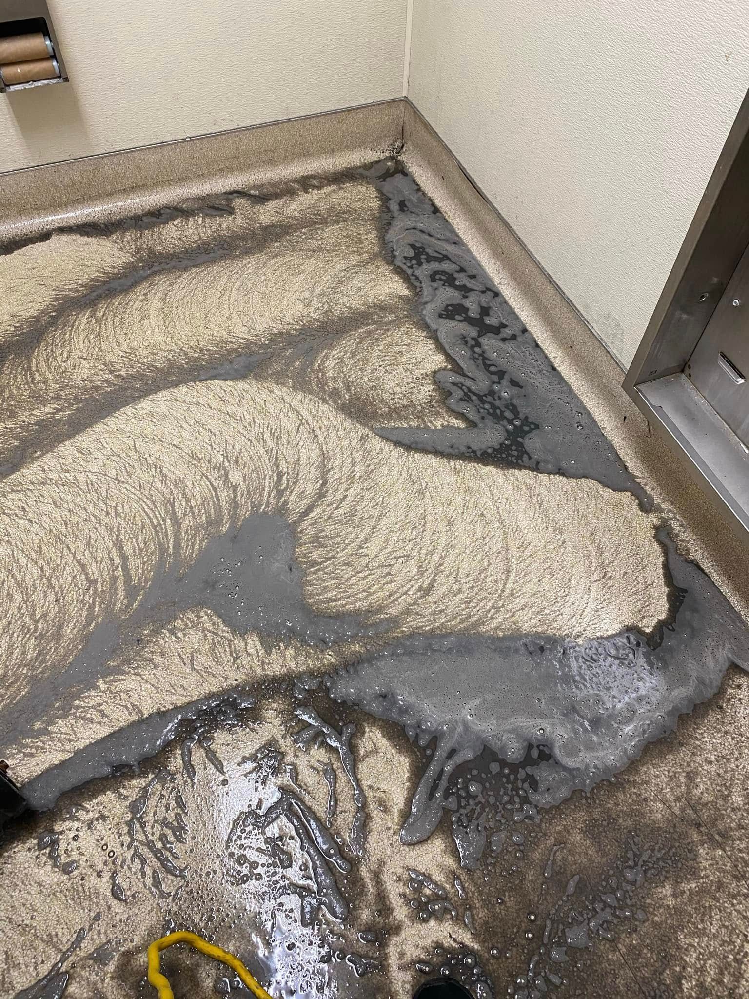 A dirty floor with a lot of water coming out of it.