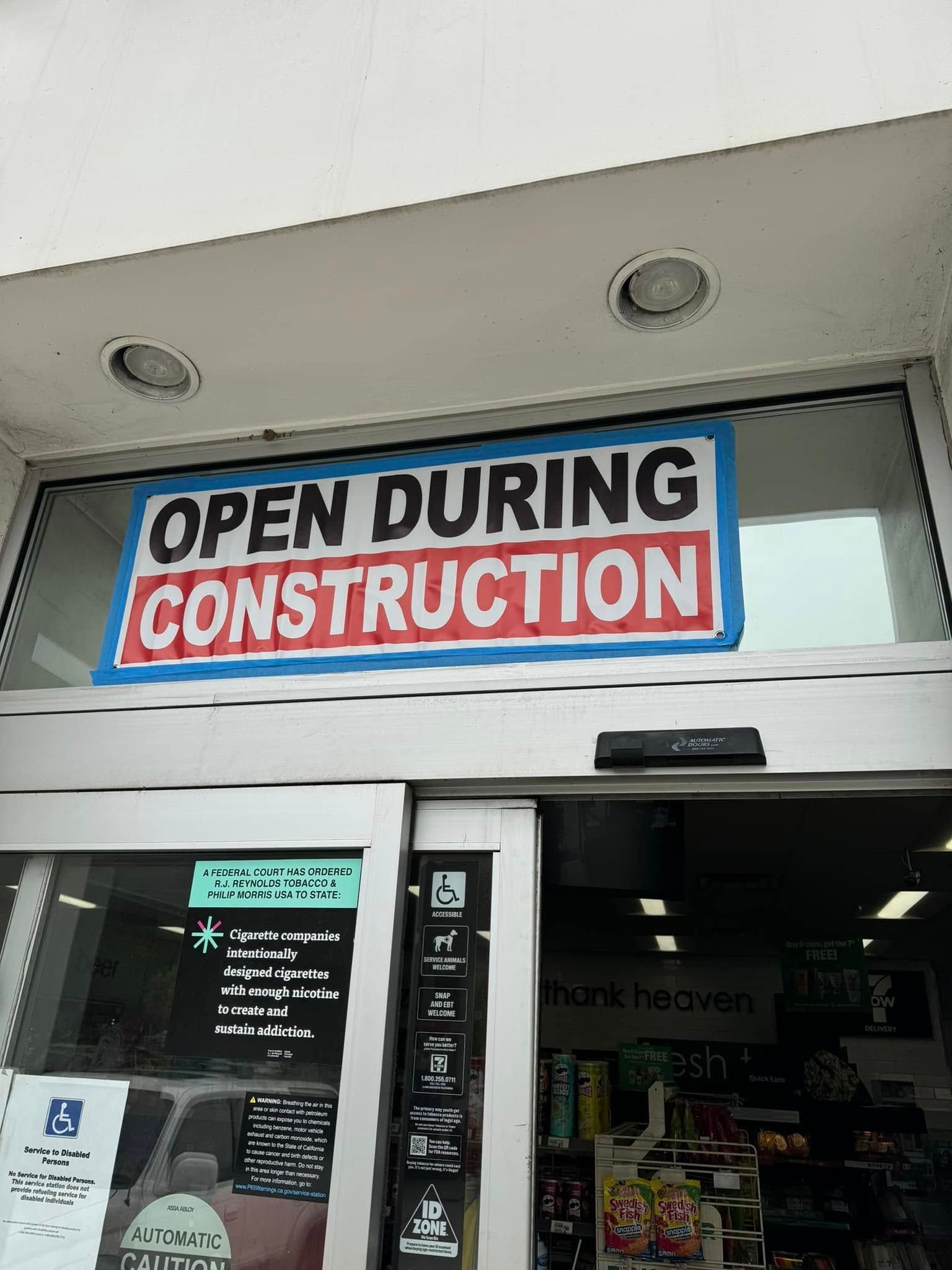 A store front with a sign that says open during construction
