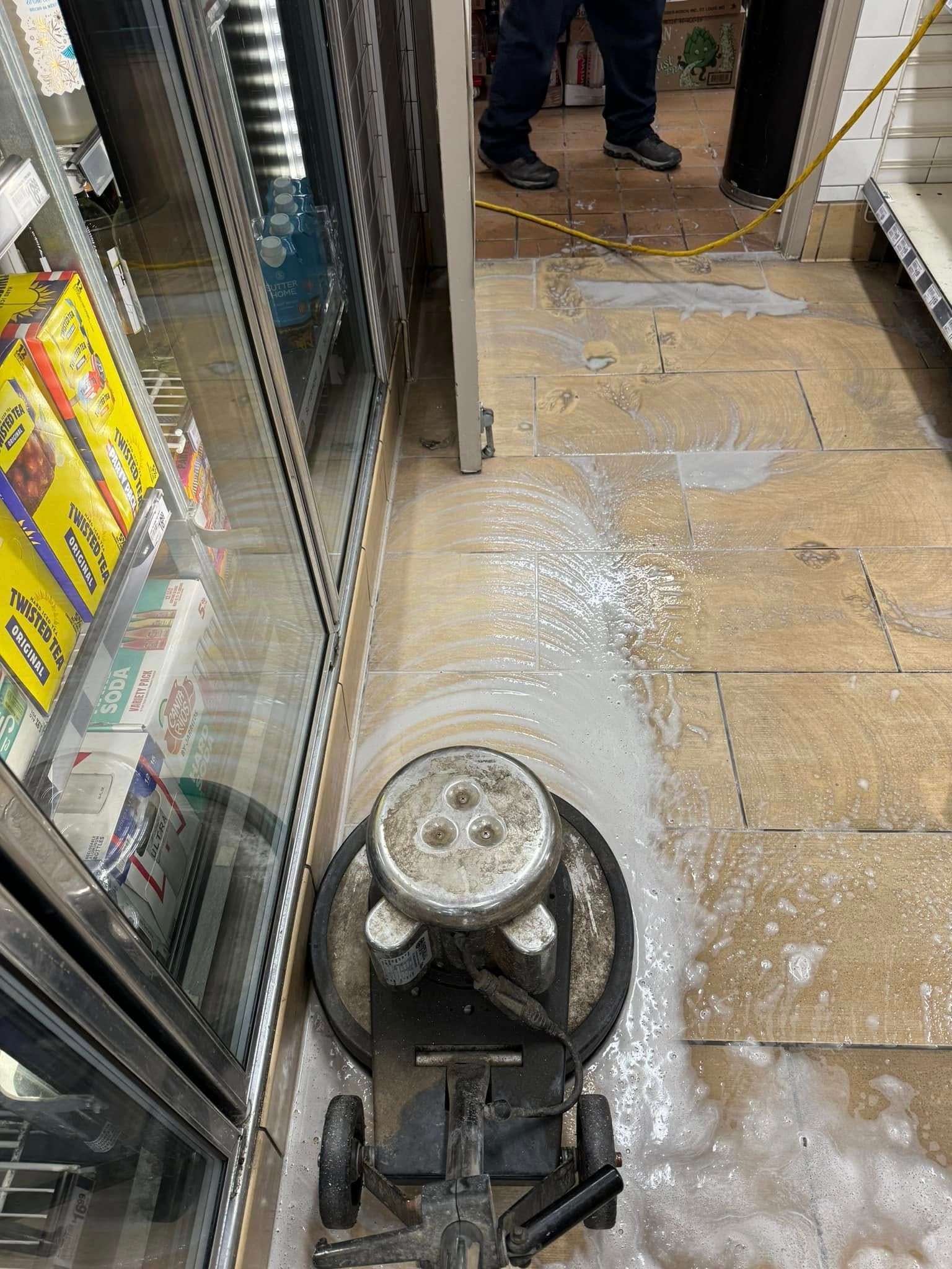 A man is cleaning the floor of a store with a machine.