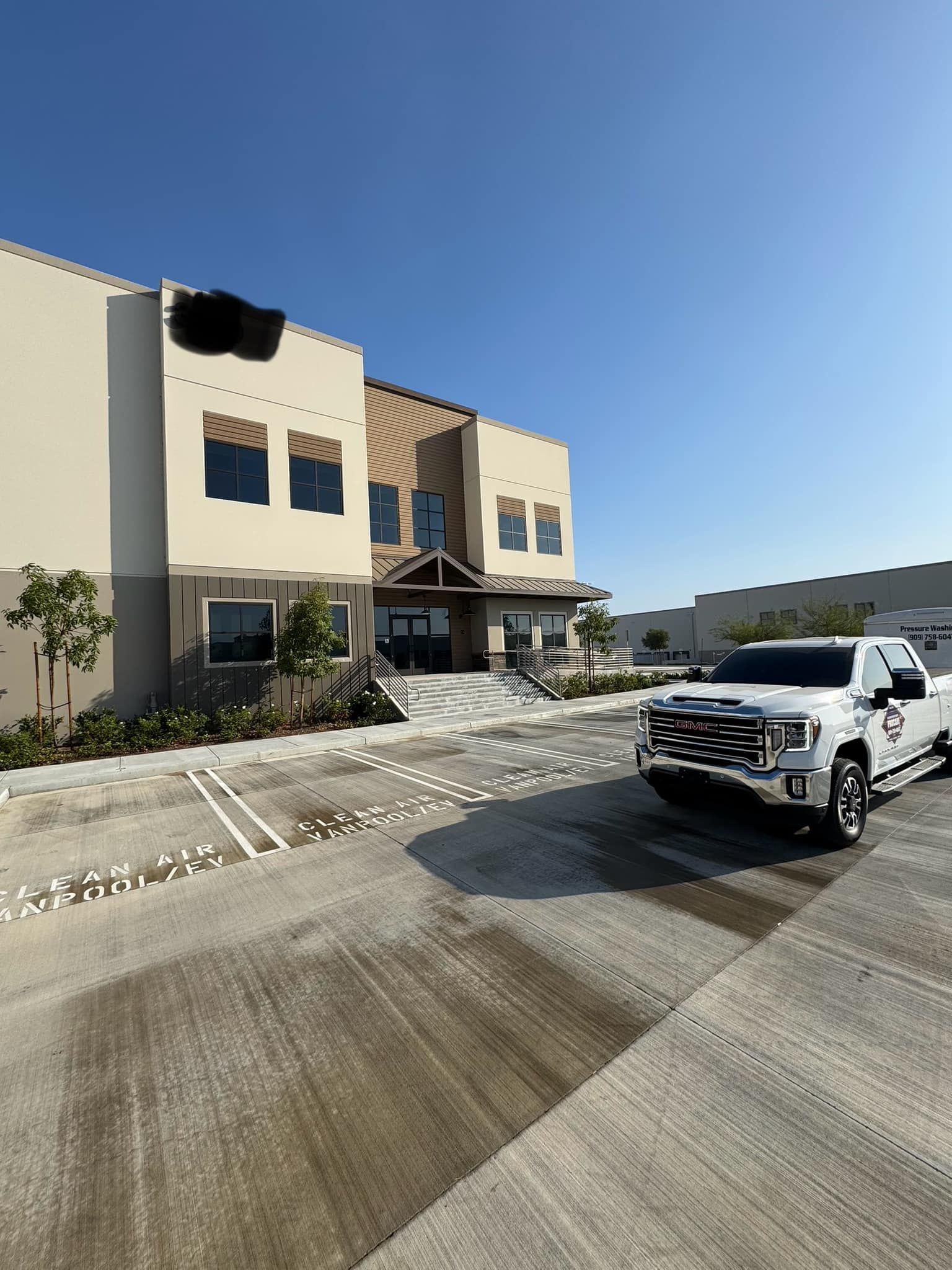 A white truck is parked in front of a large building.