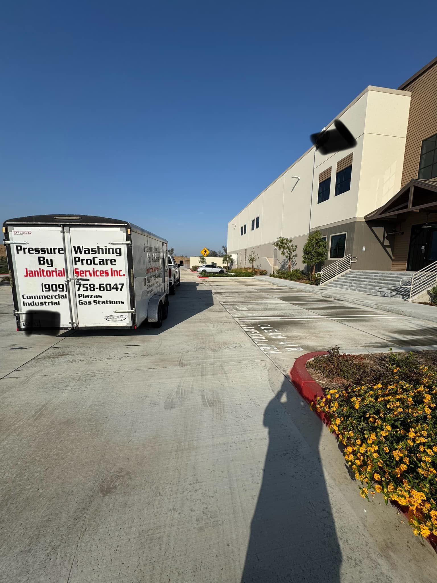 A row of moving trucks are parked in front of a large building.