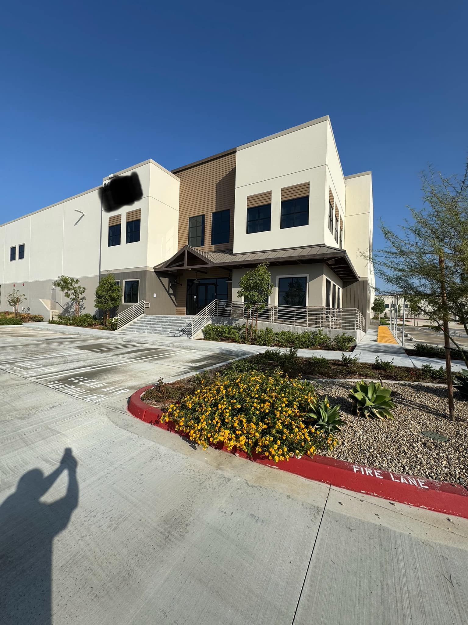 A large building with a shadow of a person standing in front of it