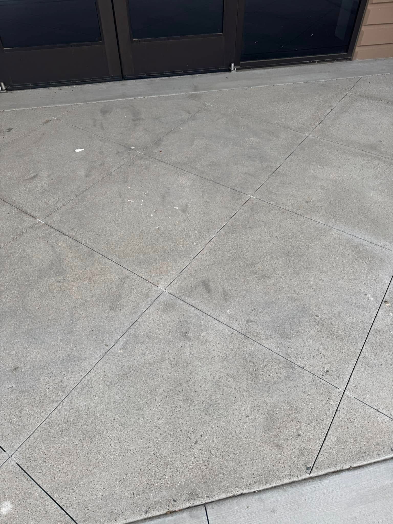 A close up of a concrete floor with a door in the background.
