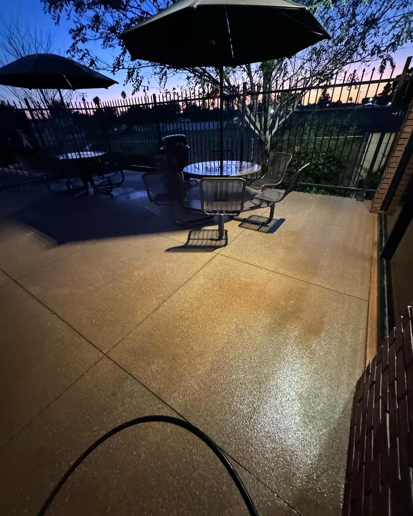 A patio with a table and chairs and umbrellas