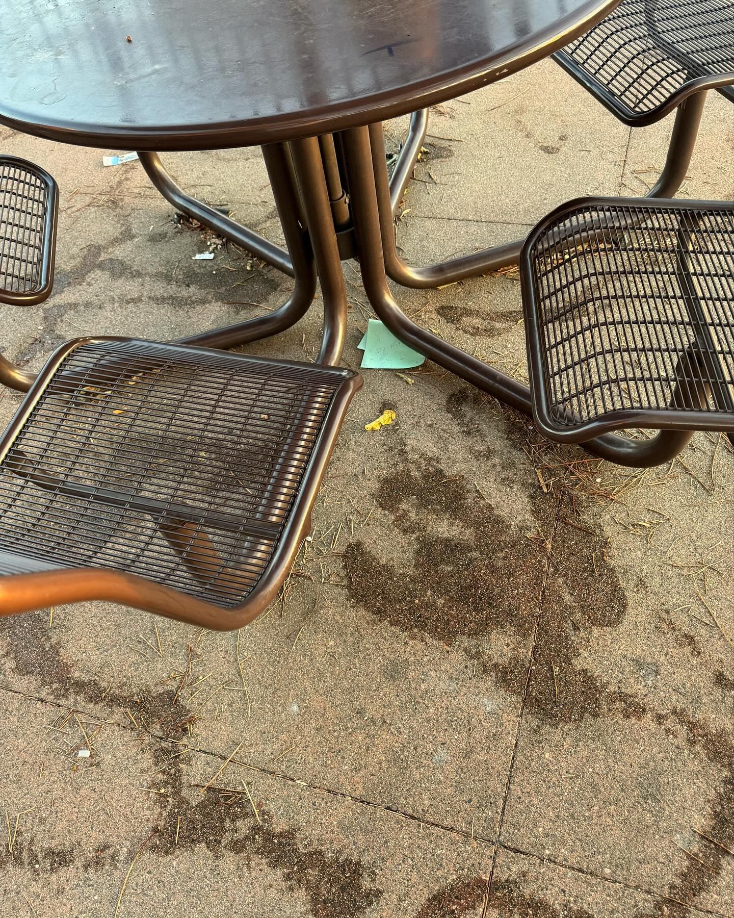 A table and chairs are sitting on a concrete surface.