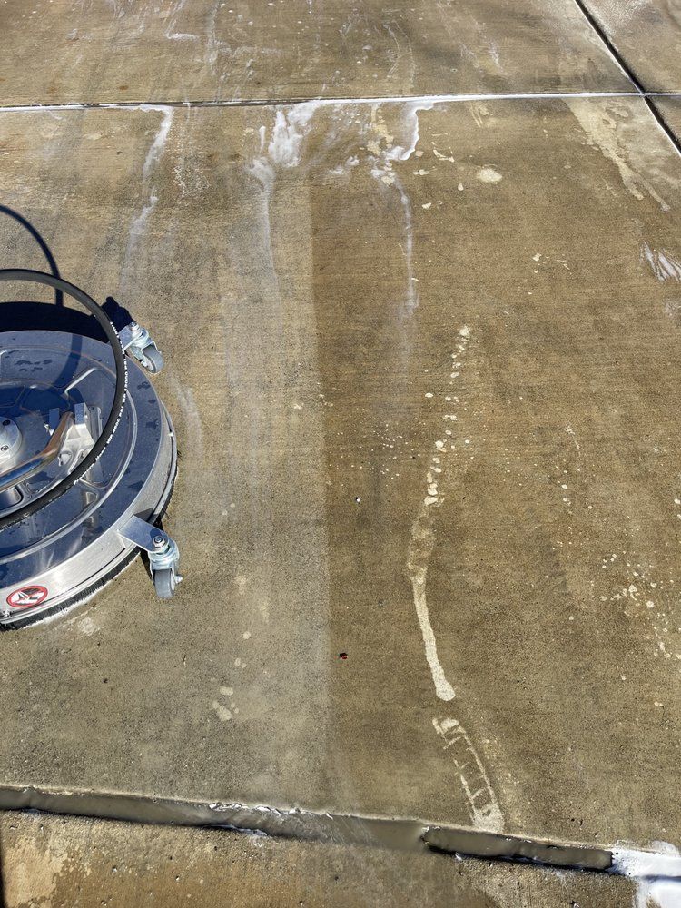 A concrete floor is being cleaned with a machine.