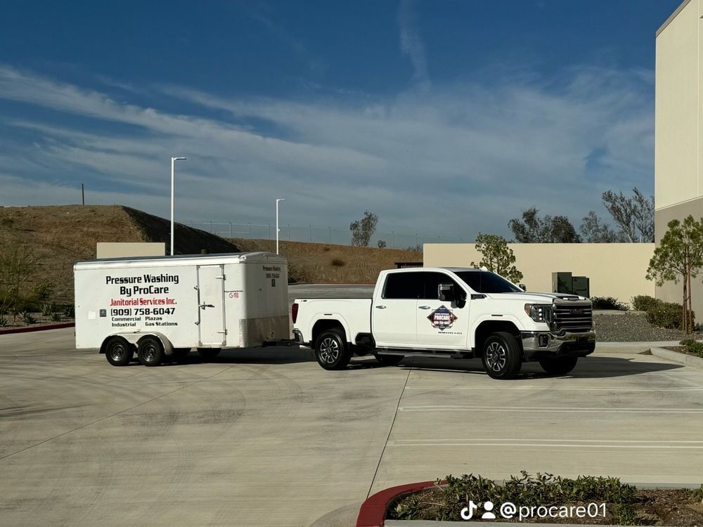 A white truck with a trailer attached to it is parked in a parking lot.