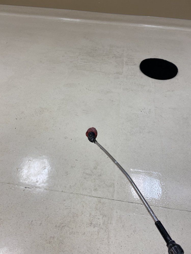 A microphone is sitting on a white floor next to a hole in the floor.
