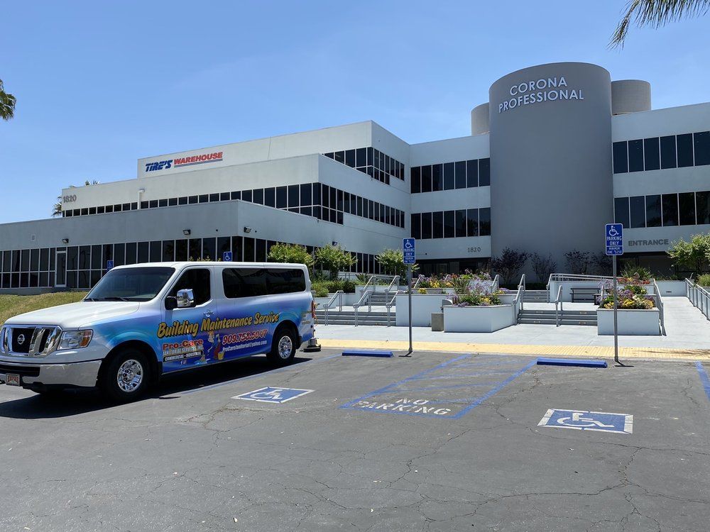 A white van is parked in front of a large building