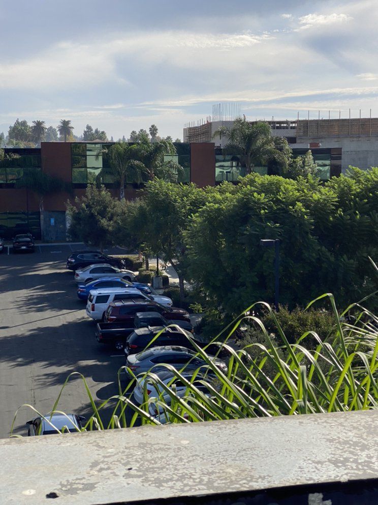 A parking lot with cars parked in front of a building