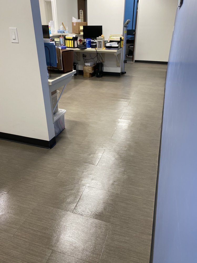 A hallway in an office with a desk and a computer on it.