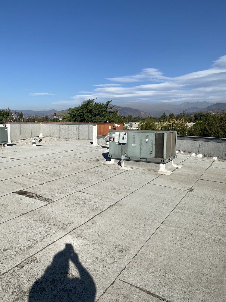 A shadow of a person is cast on the roof of a building.