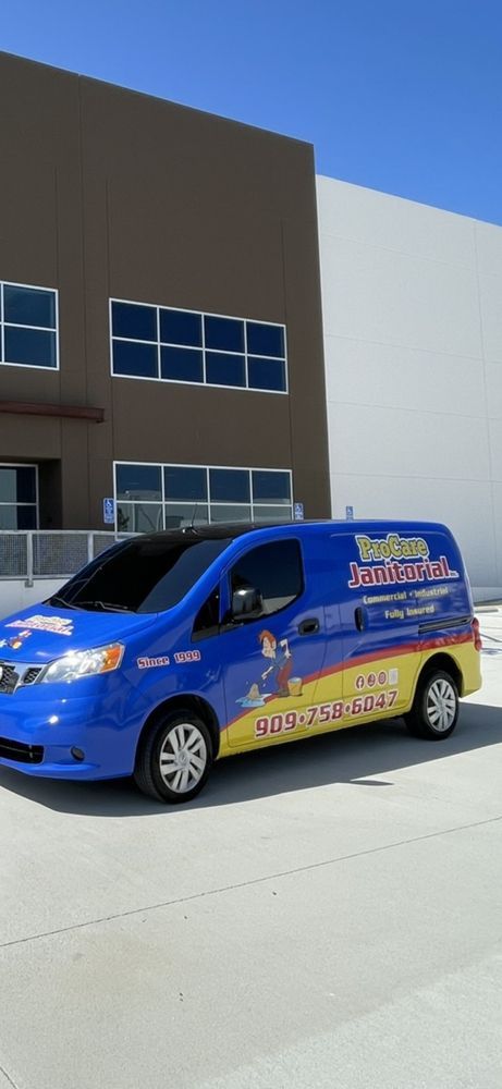 A blue and yellow van is parked in front of a building