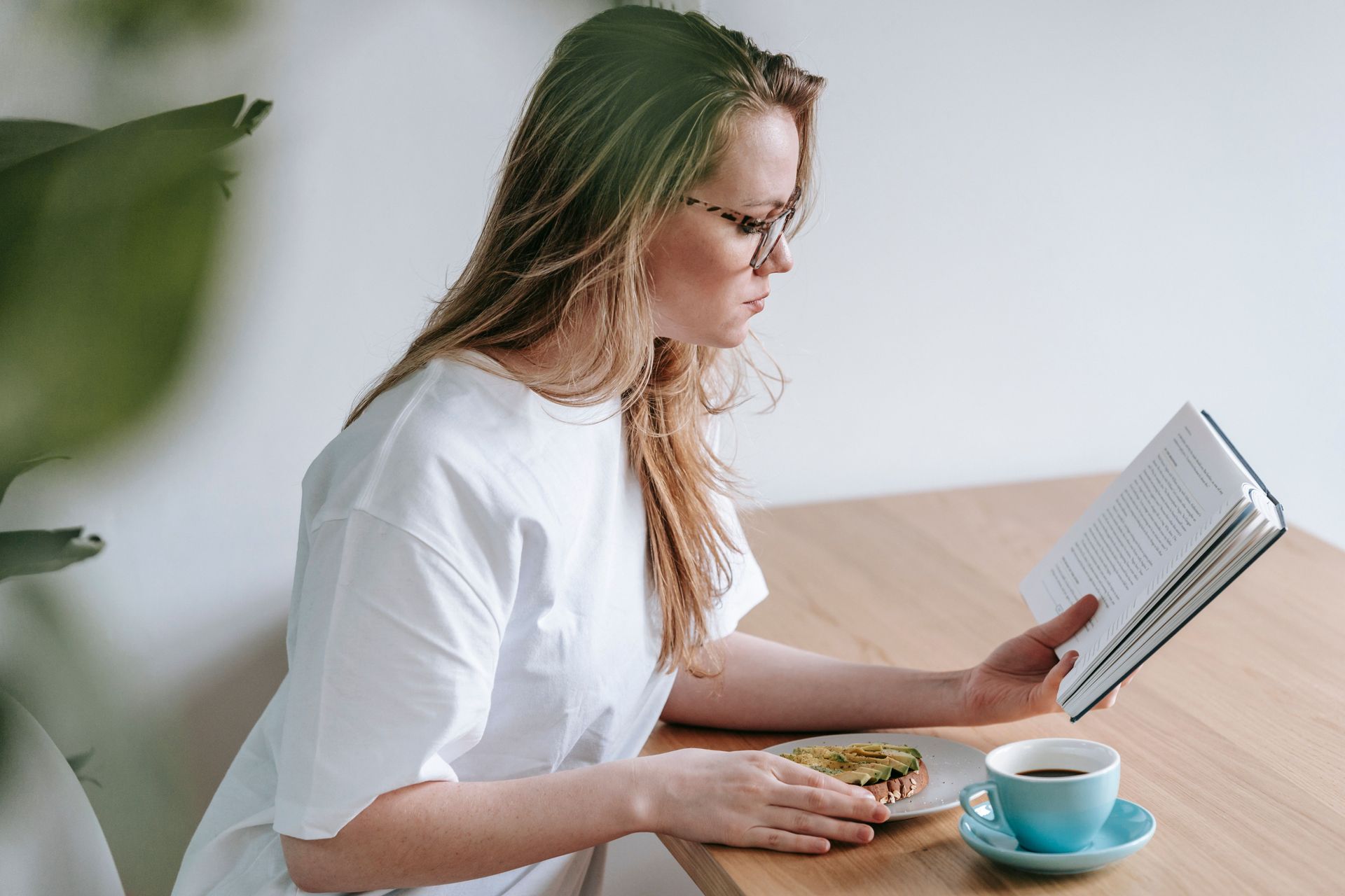 Hands exchanging a binder over a desk with coffee and notebook during a meeting