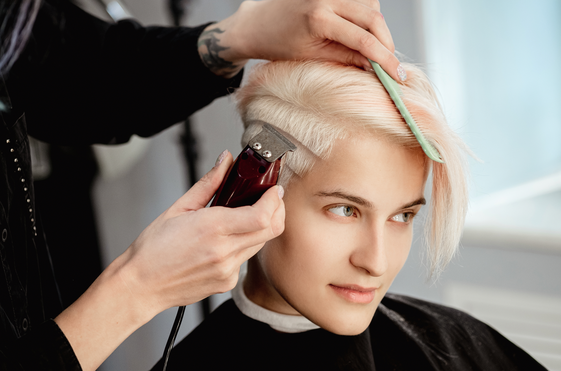A woman is getting her hair cut by a hairdresser in a salon.
